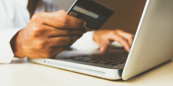 Person Using Laptop Computer Holding Card